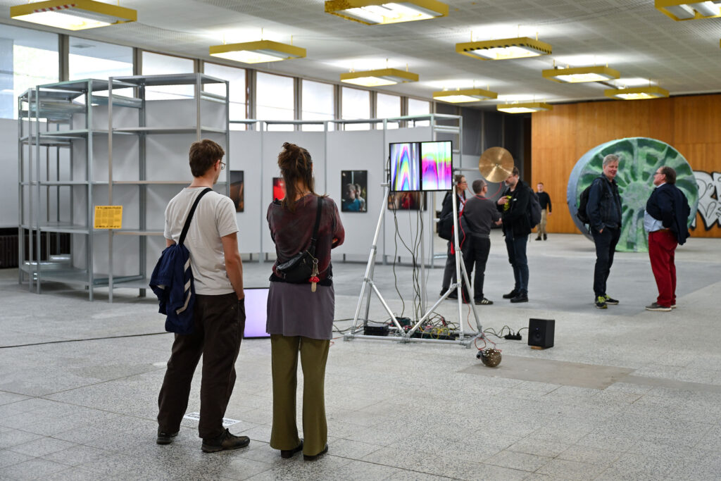 Ausstellungsansicht, TECHNO WORLDS, Besucher*innen vor der Arbeit von Robert Lippok, Ausstellungseröffnung 4.05.24, Foto: Anja Schneider